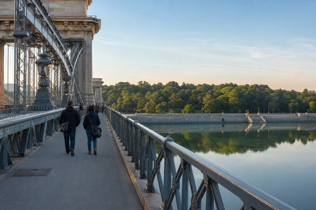 Morning walk across Margaret Bridge in Budapest toward the leafy Buda bank, the Danube wide and calm below